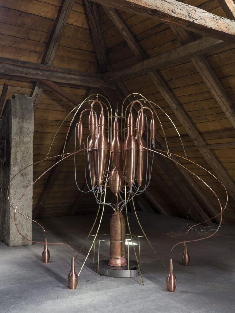 Installation view showing brass destillators arranged in the exhibition space.