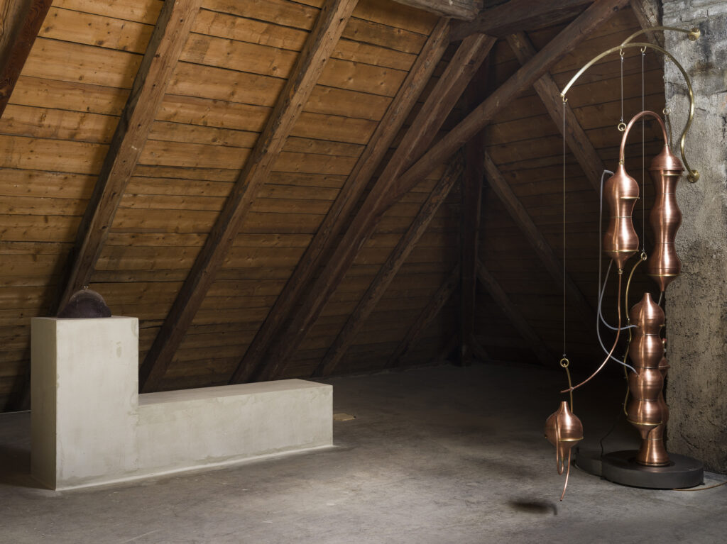 Installation view showing the the glass containers and brass destillators arranged in the exhibition space.