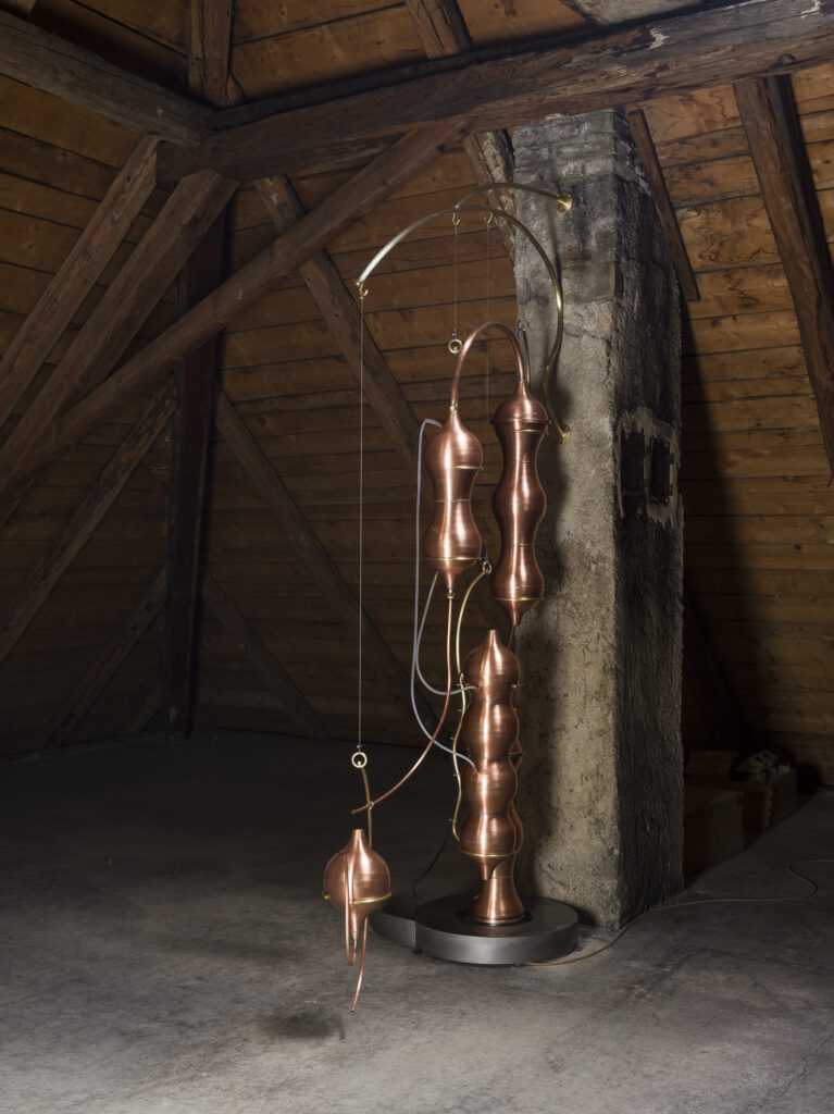 Installation view showing brass destillators arranged in the exhibition space.