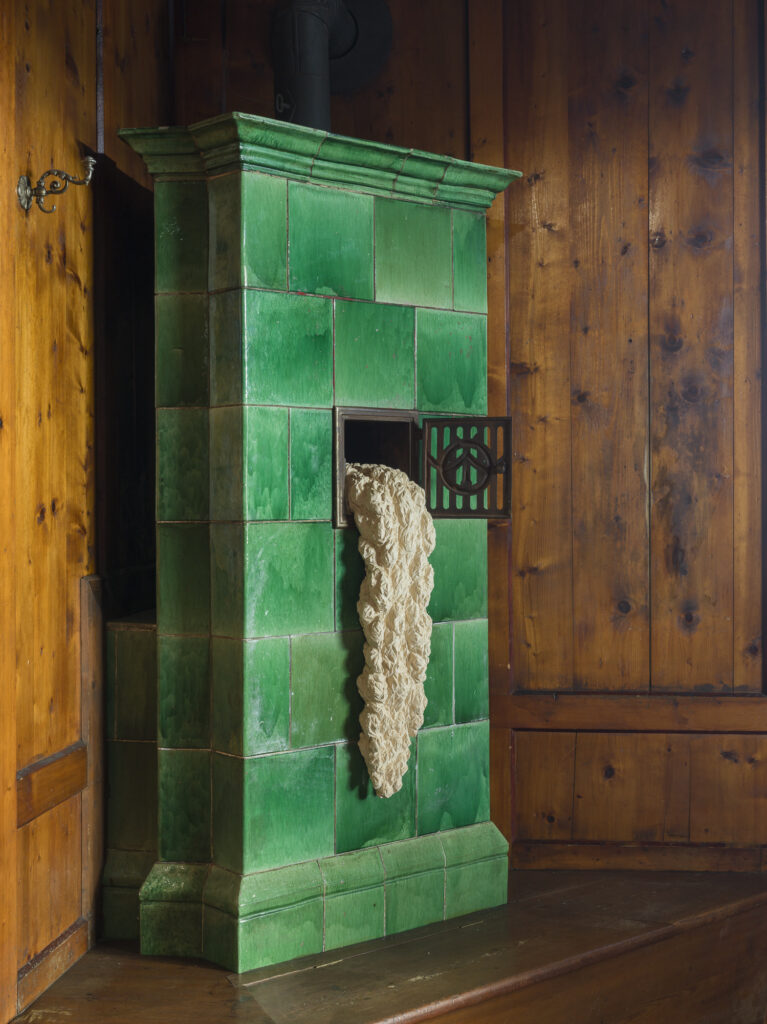 Installation view of an old hotel porters office with wood objects and paintings installed.