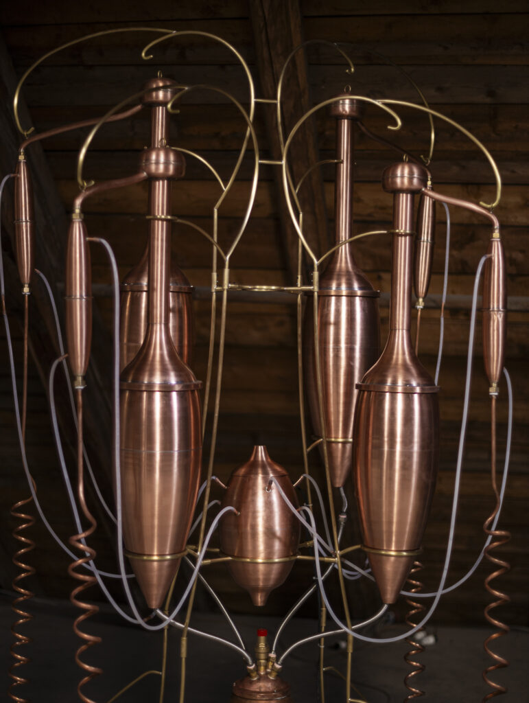 Installation view showing brass destillators arranged in the exhibition space.